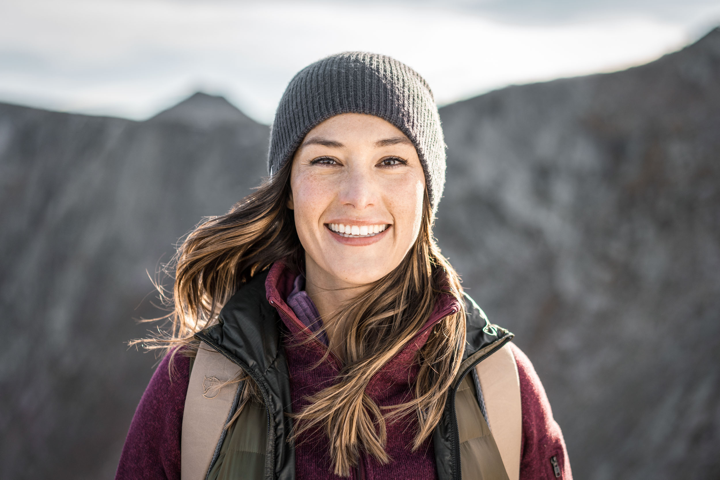 Portrait of female hiker wearing backpack and vest on a windy day on Mount Evans 